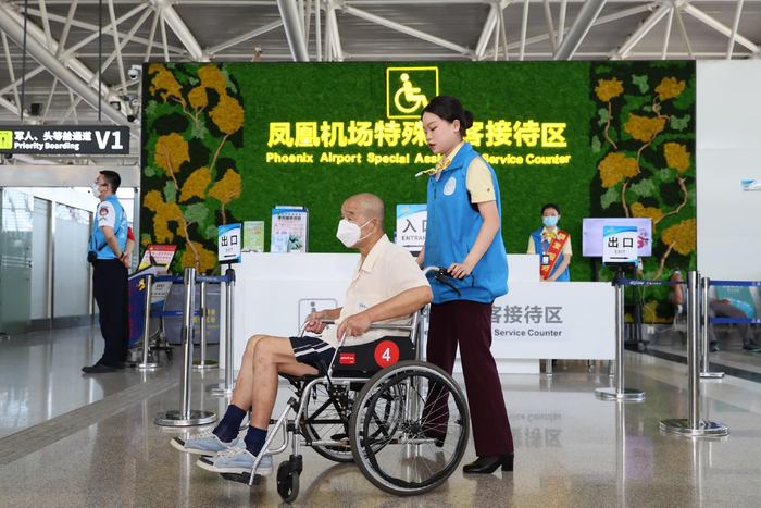 “银发”服务队保障老年旅客进港。三亚凤凰机场供图
