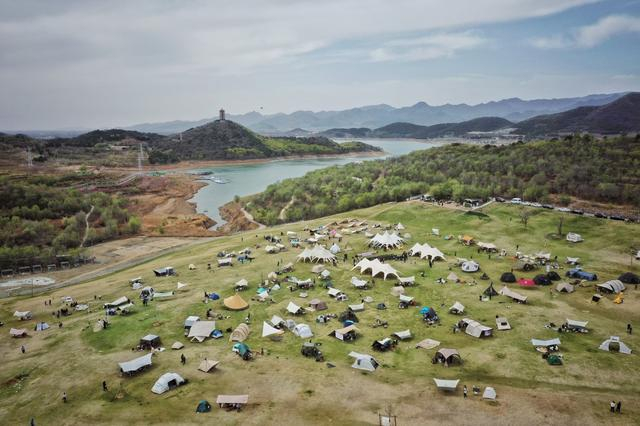 4月15日，平谷区金海湖荒野7号露营地，游客们搭起帐篷享受春日美景。新京报记者 薛珺 摄