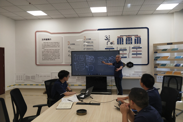 图为常德卷烟厂卷包车间劳模创新工作室里，全国劳模袁建华正在与团队成员讨论攻关项目。邓朝辉 摄