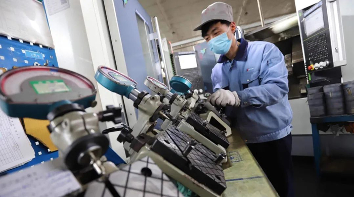 临西县一家轴承公司的生产车间，多条自动生产线全力运转，工人在生产车间内对轴承进行产品检查。（修波摄）