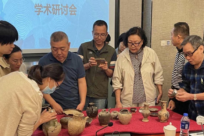 研讨会嘉宾鉴赏出土的陶器。中国搜索仇博摄