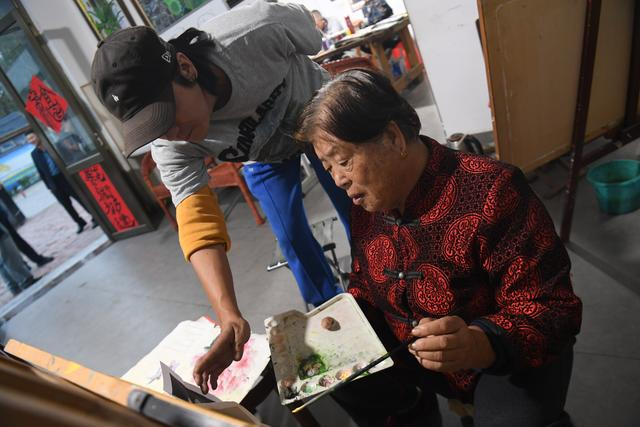 10月12日，蔡家沟村的农民画廊中，画家正在指导村民学习绘画。新京报记者 王颖 摄