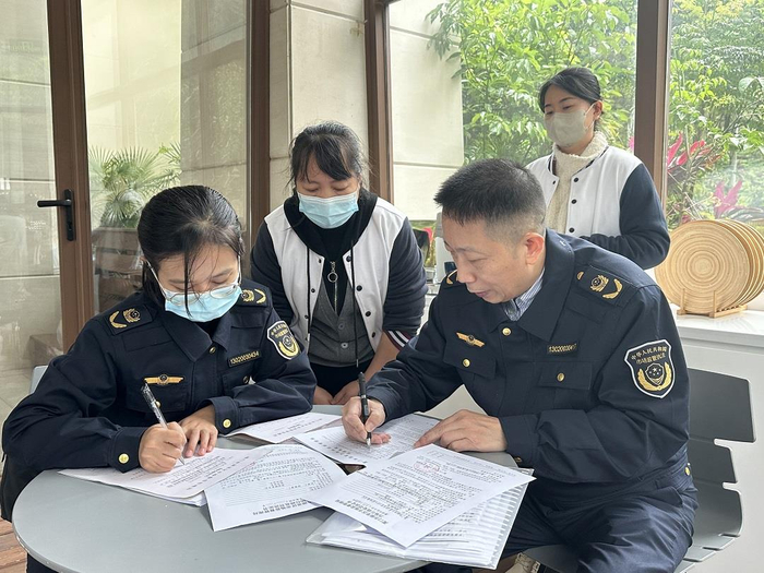 对涉嫌违法餐饮企业，市场监管执法人员现场开具行政处罚决定书。