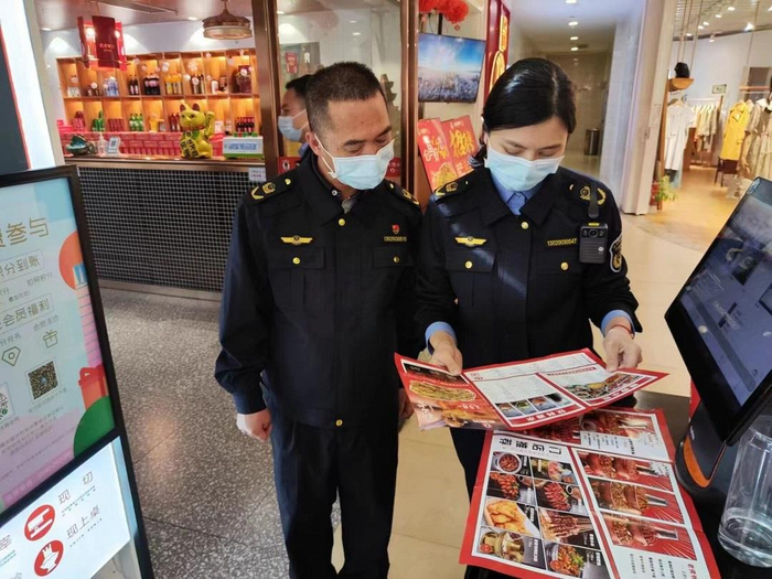 市场监管执法人员对餐饮企业进行检查。