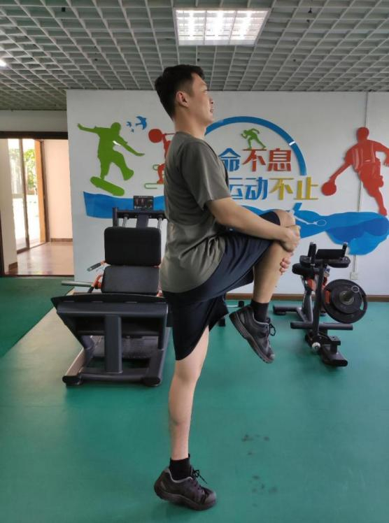 进行抱膝提踵的热身动作。郭晓宇 摄