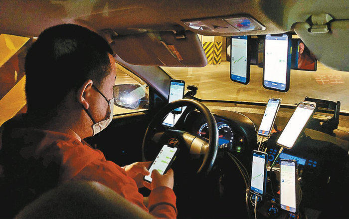 一位出租车司机在车内用九台手机抢单