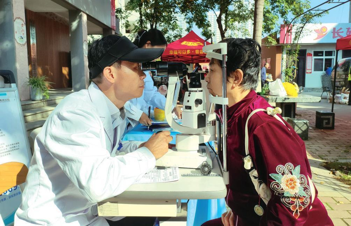 志愿者为世家星城社区的老年人检查眼睛。