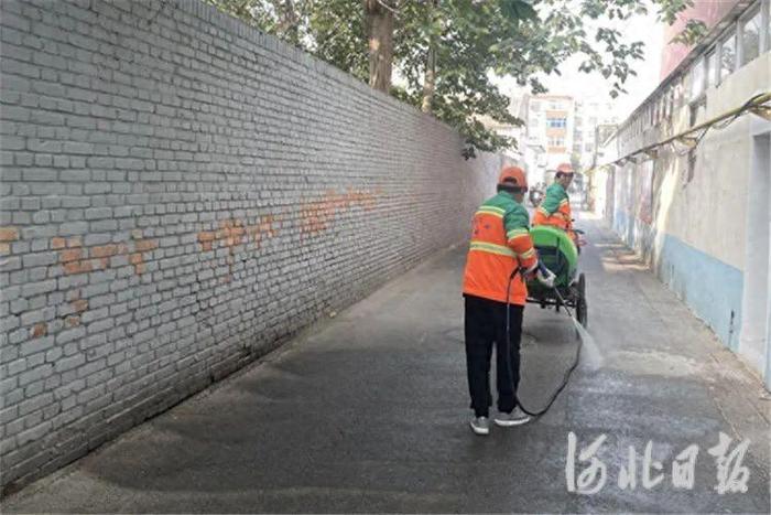 图为廊坊市广阳区环卫职工使用小型高压清洗机对路面进行冲洗。