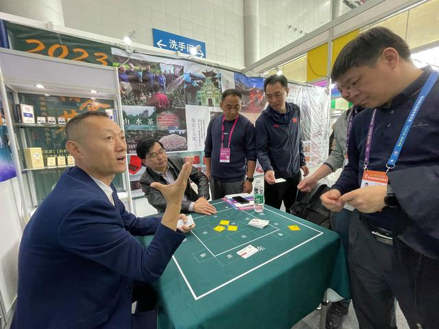 智博会上，薛文（左一）带来了公司研发的掼牌、报牌卡等。 新京报记者 孙海光 摄