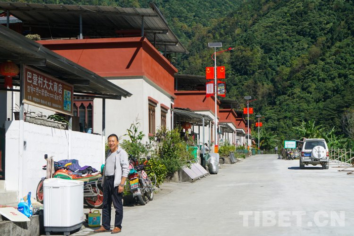 　　图为谭楚成正在自家房子门前向记者介绍西藏和平解放70周年中央代表团赠送西藏群众的礼品洗衣机 摄影：赵振宇