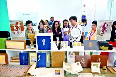 参观者在第十三届中国旅游产业博览会中国国家图书馆展区挑选文创产品。 新华社发
