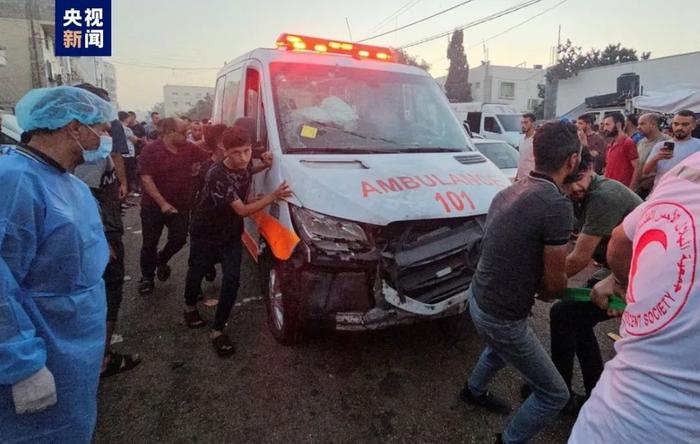 △11月3日，加沙地带希法医院外一队救护车车队遭袭后，当地民众与救援人员推行车辆。