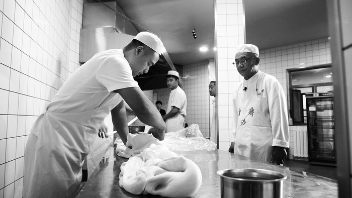     马文斌（右一）指导拉面师傅进行牛肉面制作