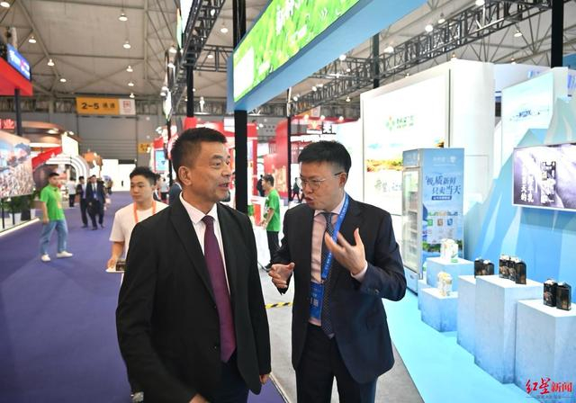 ▲新希望集团董事长刘永好在自己企业展台前 资料图