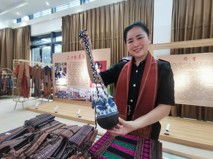 唐秋晨展示黎锦手工艺品。记者 李绍远 摄