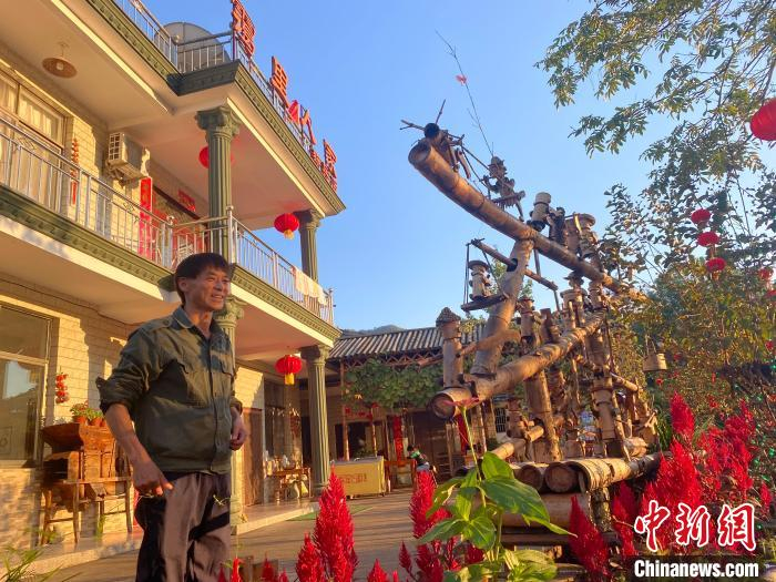 10月17日，杨新兵在家门口向游客介绍他眼前的自制小水车。中新社记者 吴兰 摄