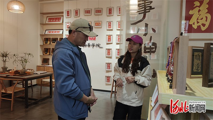 11月1日，“拓菩学院”手作店店长王丹（右）在向游客介绍拓印作品。河北日报记者史晓多摄