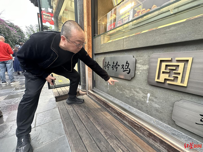 ▲韩先生将“伤心凉粉”标牌取下，留下空白