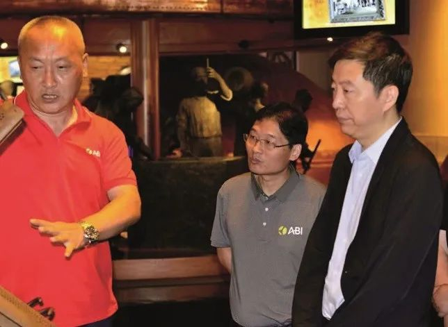 上图：何勇（右一）参观哈尔滨啤酒厂。