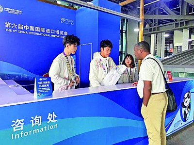 进博会上的青年志愿者在提供服务。光明日报记者 颜维琦摄/光明图片