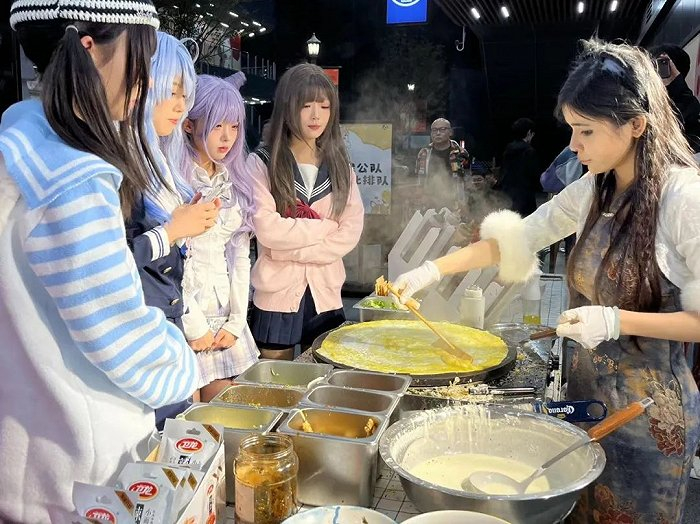 ▲ 几位coser在煎饼摊买煎饼。图 / 每日人物摄