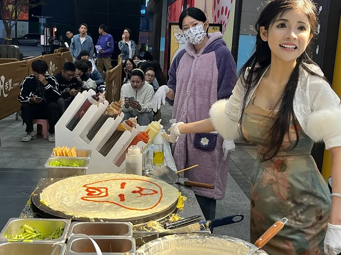 ▲ 狗头萝莉摊煎饼，她用番茄酱在面饼上涂了一只狗。图 / 每日人物摄