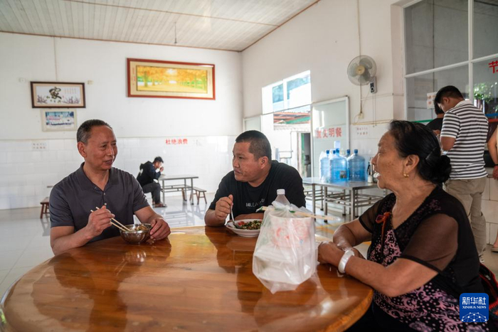在畹町仁慈医院，沈坤（左）在食堂吃饭时和病人家属交流病情（11月7日摄）。新华社记者 胡超 摄