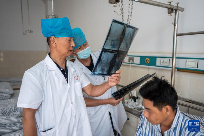 在畹町仁慈医院，沈坤（左）在查房时查看病人病情（10月29日摄）。新华社记者 胡超 摄