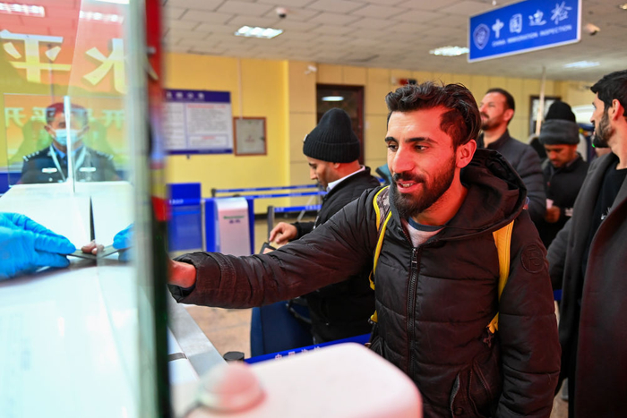 11月6日，在新疆红其拉甫口岸联检大厅，红其拉甫边检站民警为出境旅客办理边检手续。新华社记者丁磊 摄