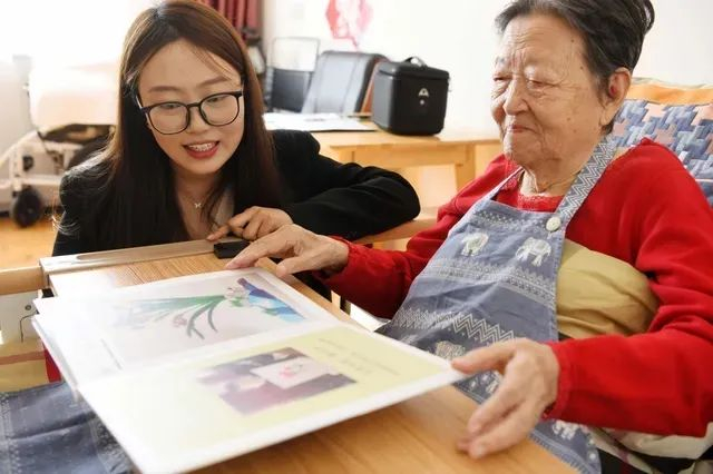 10月26日，在北京一家颐养中心，隋爱莲老人向记者展示她的作品集。健康时报记者牛宏超摄