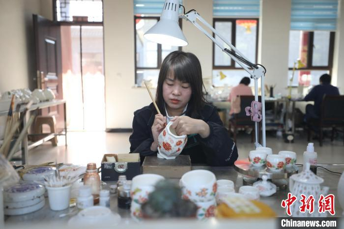 八义窑彩绘工作人员正在明亮的灯光下彩绘瓷器制品。国网山西长治上党区供电公司供图