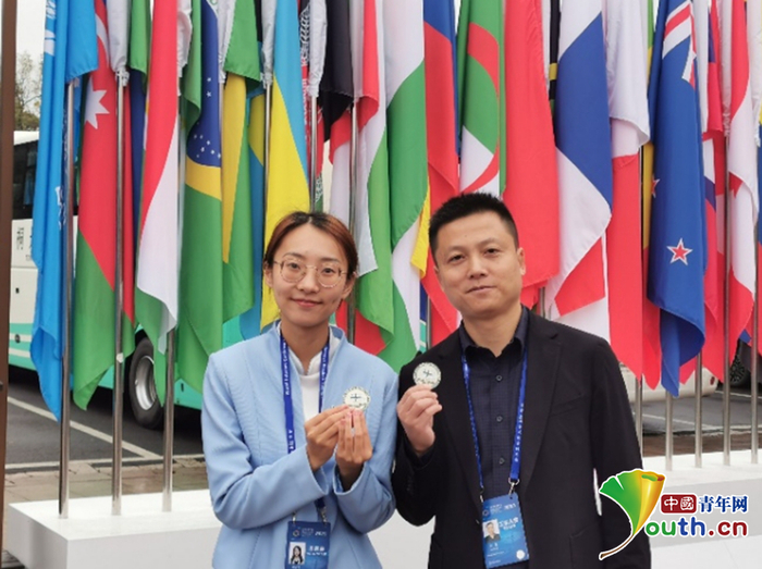 刘存钰（左）和联络员手持嘉宾赠予的勋章。受访者供图