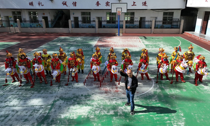 罗长超带领晓道小学竹马队在操场上排练“晓道竹马”