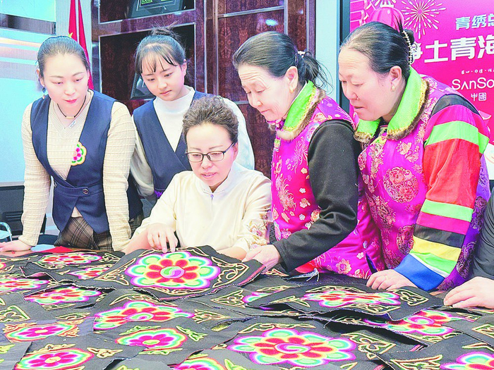 苏晓莉与绣娘们交流技艺。企业供图