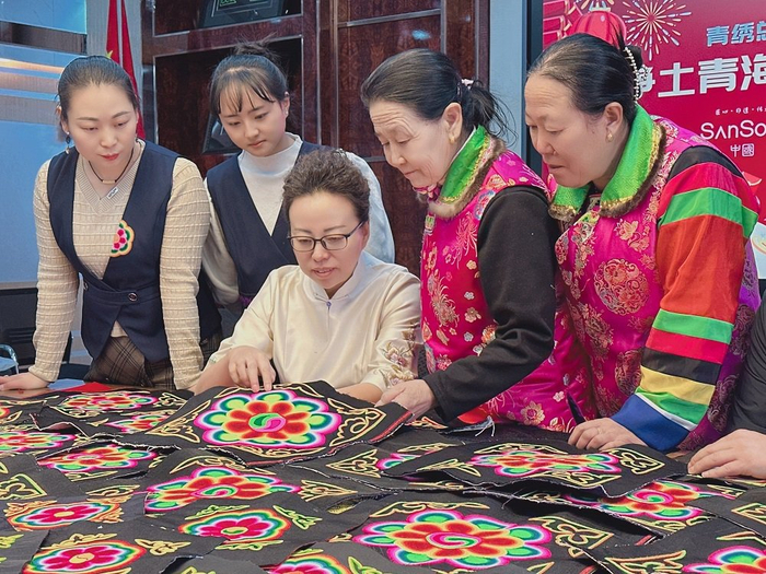 苏晓莉与绣娘们交流技艺。企业供图