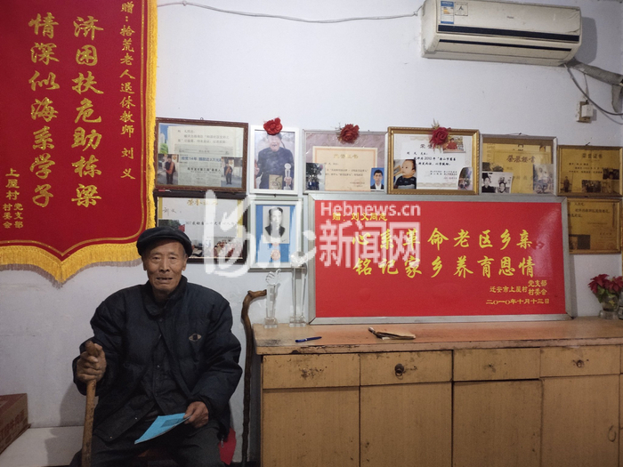 刘义老人家中一面墙挂满了锦旗和荣誉证书。（来源/建国里社区供图）