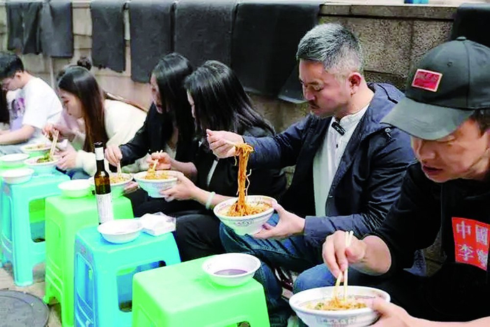     邹徐（右一）在路边吃面