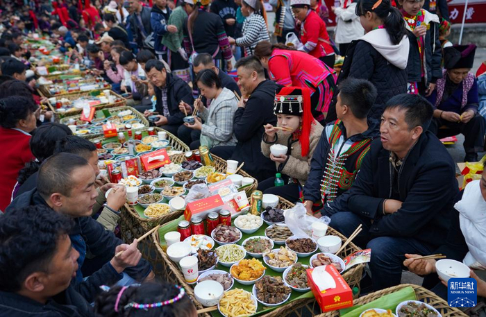 11月19日，绿春县哈尼族群众与游客一起品尝哈尼长街古宴。新华社记者 陈欣波 摄