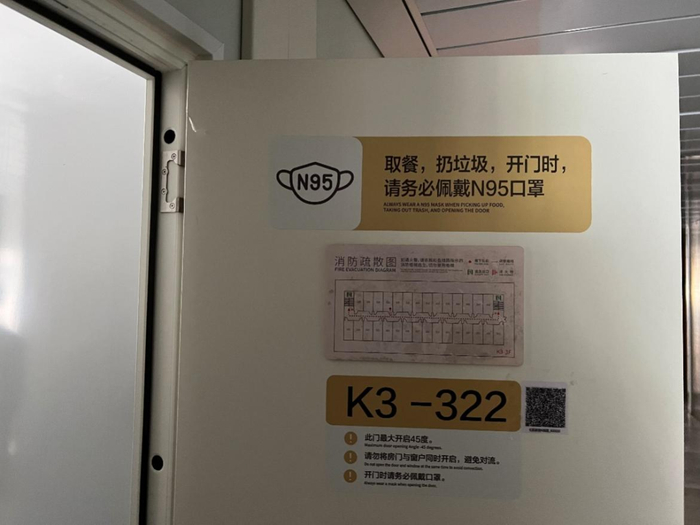 房间门上仍张贴着疫情防控有关的提示