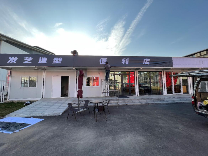 园区内正在安装广告牌的理发店