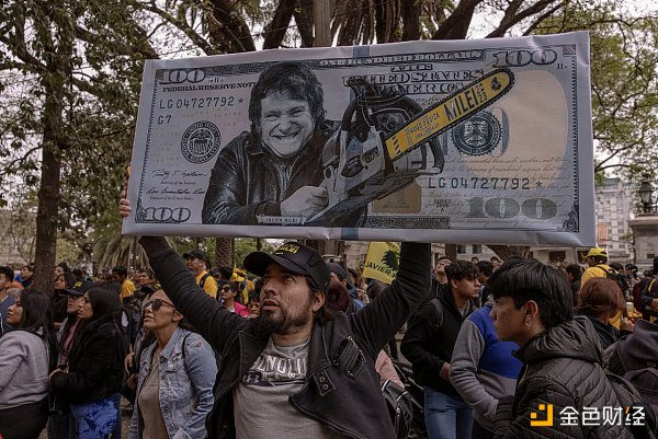 阿根廷选民举着代表米莱两大竞选承诺的图标