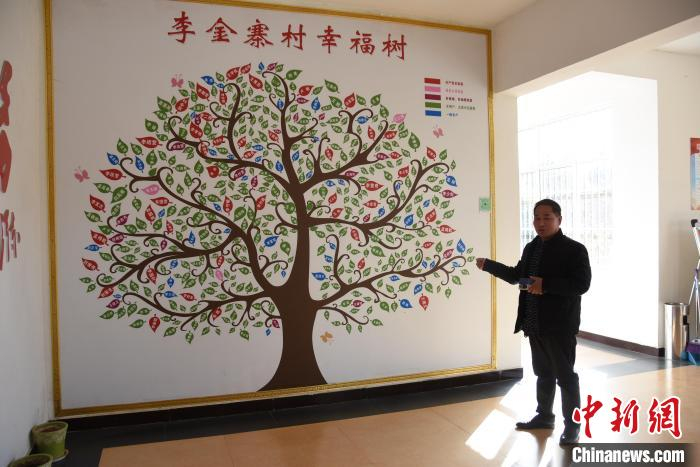 李金寨村党支部宣传委员李发志介绍“幸福树”。　　王宇 摄