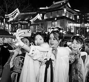     身穿汉服的游客在洛阳洛邑古城内拍照。新华社发