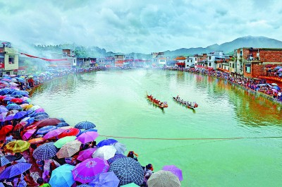 客家文化（赣南）生态保护实验区内举行的民俗活动杨村池塘龙舟赛，吸引了大批村民冒雨观看。李加淳摄/光明图片