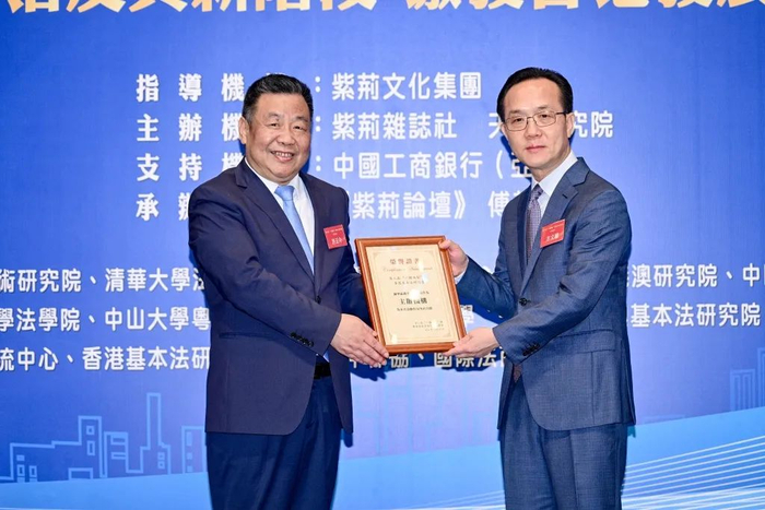 紫荆文化集团董事长许正中代表研讨会组委会为主办机构天大研究院颁发纪念牌，天大研究院董事长方文权代表接受颁牌