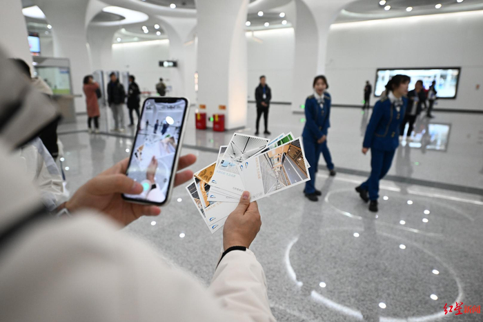 ▲参与试乘的市民拿着明信片打卡