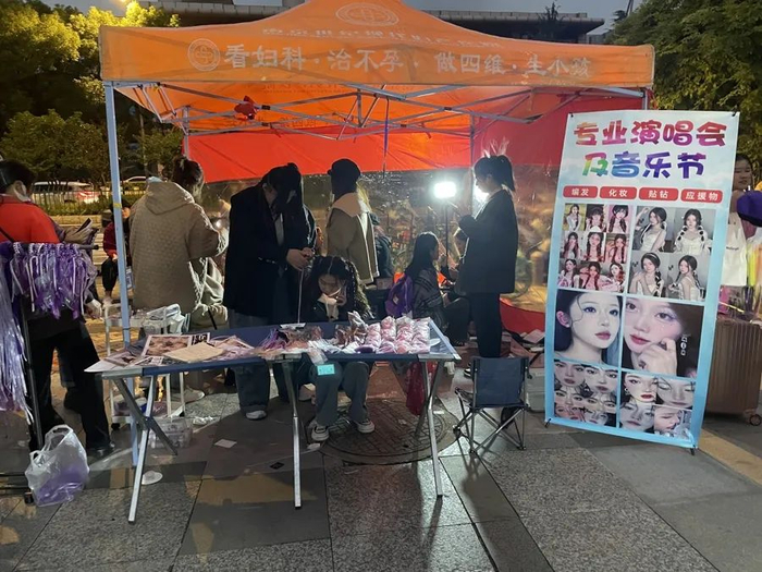 11月11日，南京奥体中心场馆外的编发和化妆摊位，部分摊位渐渐开始扩张规模。