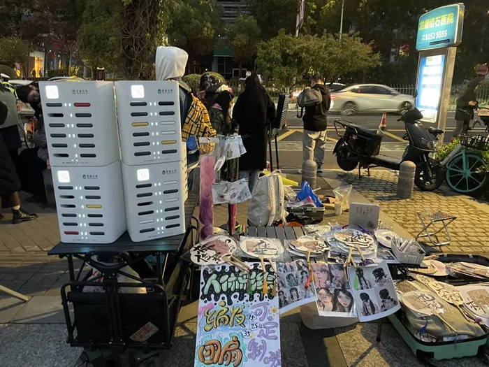 11月11日，南京奥体中心场馆外的摊位，主要出租充电宝、售卖演唱会周边产品。