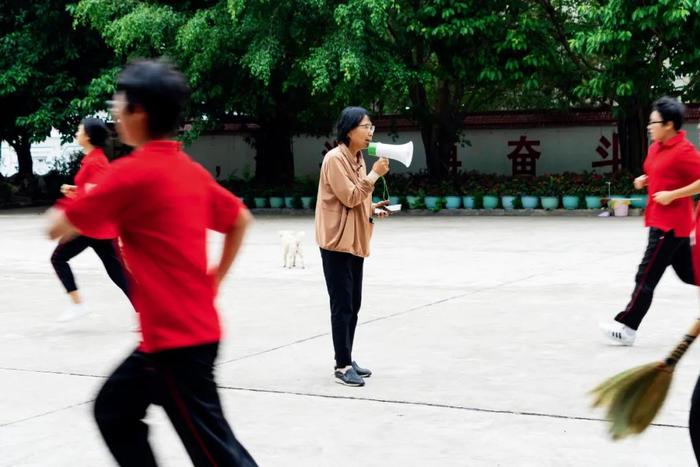 7月4日，张桂梅用喇叭催促学生打扫操场。图/新华