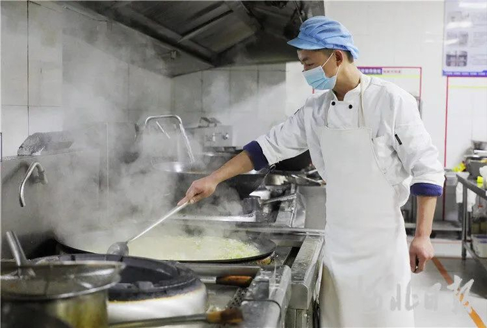 图为11月22日，在固安县第一中学食堂的烹饪间，工作人员正在熬汤。通讯员孙瑞琳摄